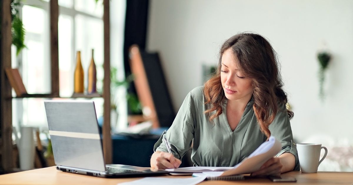 Women using laptop and writing notes in a notebook