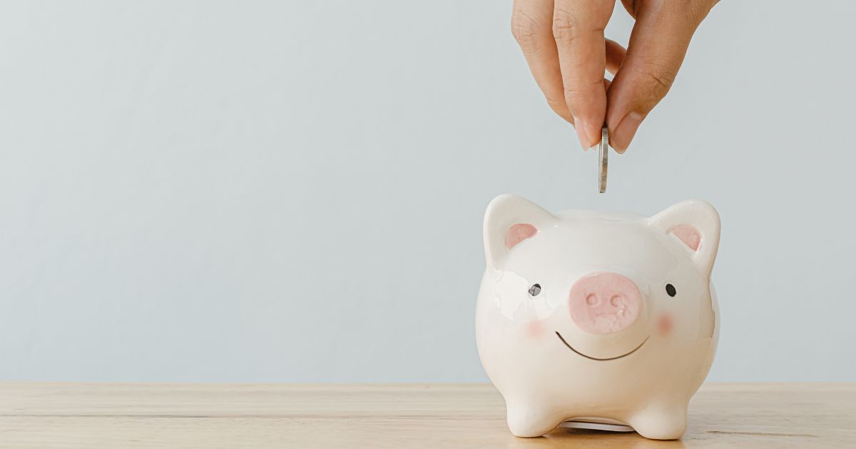 someone putting a coin into the piggy bank