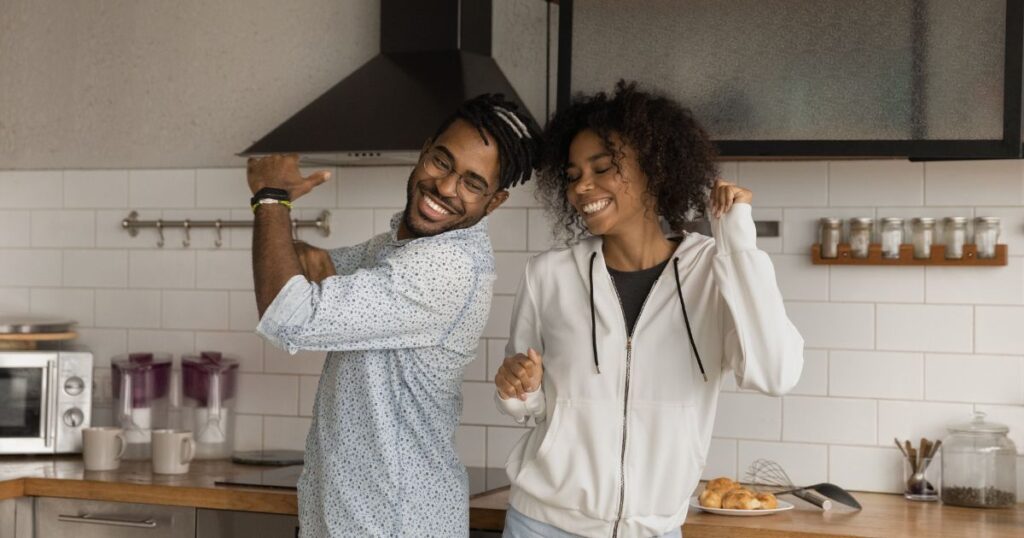 Couple dancing together in modern kitchen.